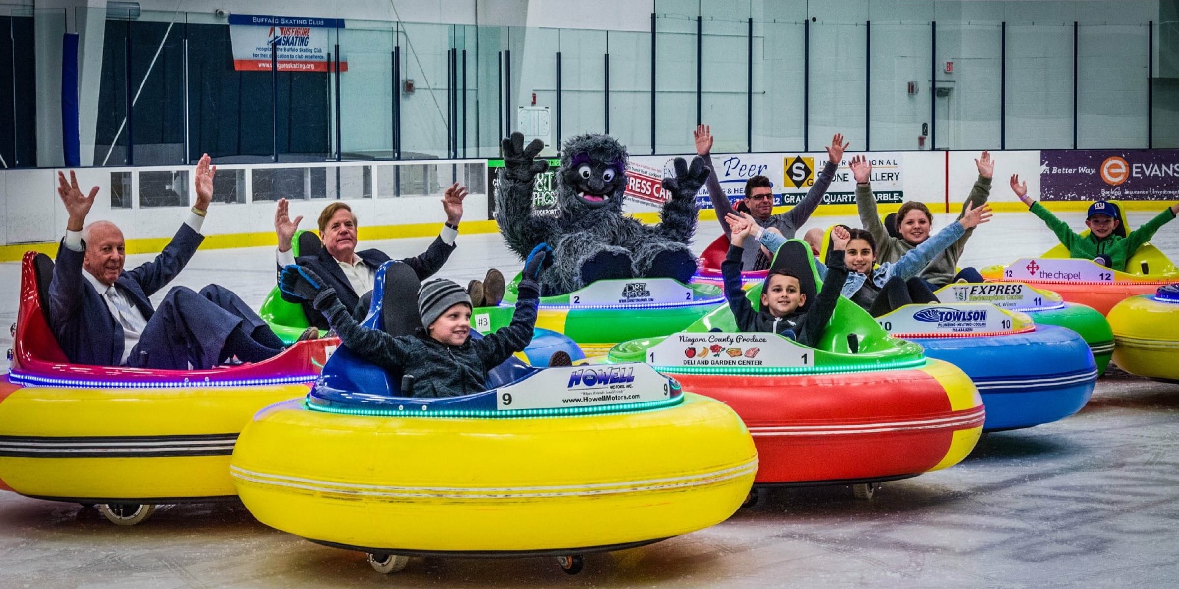 Cornerstone Ice Arena mascot sitting in an ice bumper car on the ice with other people in ice bumper cars